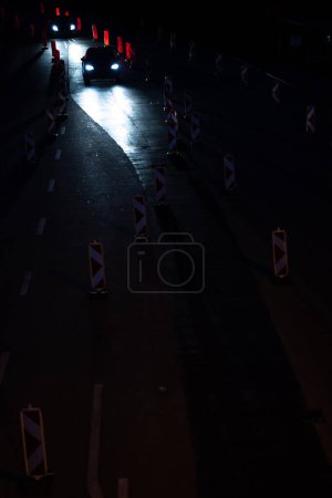 Foto de Coches en una carretera con obras de carretera. Trabaja en la carretera. Tráfico nocturno. - Imagen libre de derechos