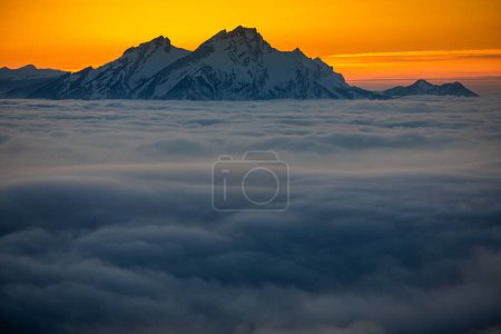 Foto de Espléndido paisaje apline. Altas montañas con niebla y hermosa luz de la noche. - Imagen libre de derechos