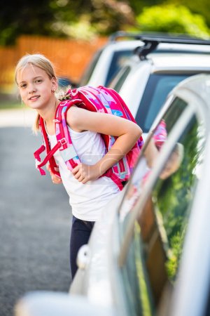 Téléchargez les photos : Petite fille mignonne rentrant de l'école, regardant bien avant de traverser la rue - en image libre de droit