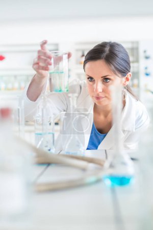 Photo for Young, female researcher carrying out experiments in a lab (shallow DOF; color toned image) - Royalty Free Image