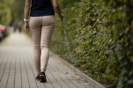Photo for Blind woman walking on city streets, using her white cane - Royalty Free Image