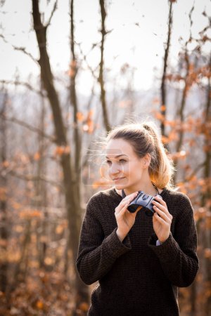 Foto de Mujer joven con prismáticos al aire libre en el día de otoño. Disfrutando del aire libre. - Imagen libre de derechos