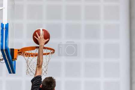 Téléchargez les photos : Balle de basket sur terrain de sport en bois. Joueurs de basket-ball junior jouant à un jeu en arrière-plan flou. Basket-ball Formation Contexte. - en image libre de droit