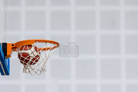 Téléchargez les photos : Balle de basket sur terrain de sport en bois. Joueurs de basket-ball junior jouant à un jeu en arrière-plan flou. Basket-ball Formation Contexte. - en image libre de droit