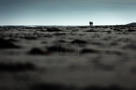 Foto de Happy senior man and woman old retired couple walking and holding hands on a beach at sunset - Imagen libre de derechos