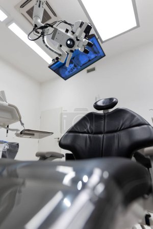 Foto de Interior de la clínica de tratamiento dental con silla de paciente moderna y un televisor por encima - Imagen libre de derechos