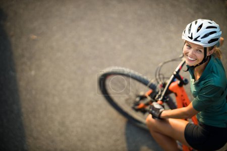 Téléchargez les photos : Jolie, jeune femme avec son vélo de montagne va faire un tour au-delà des limites de la ville, obtenir la dose cardio quotidienne - en image libre de droit