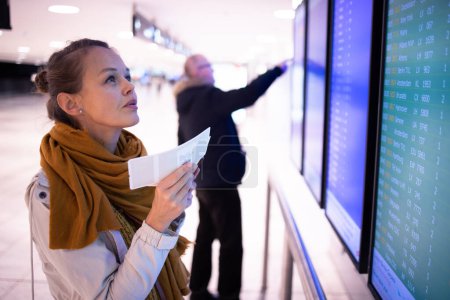 Photo for Canceled flight situation - Young, pretty female traveler learning about her flight being canceled, unable to get home today - Royalty Free Image