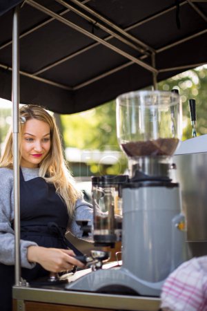 Foto de Abogada femenina haciendo café para clientes en un puesto de café móvil al aire libre en una ciudad - Imagen libre de derechos