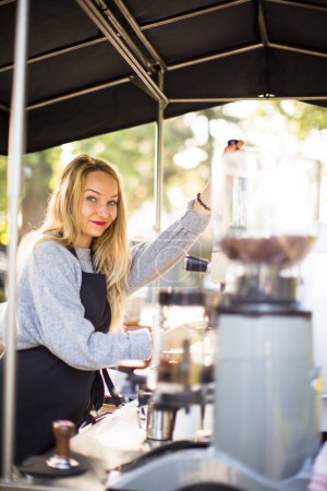 Téléchargez les photos : Femme barrista faire du café pour les clients dans un stand de café mobile à l'extérieur dans une ville - en image libre de droit