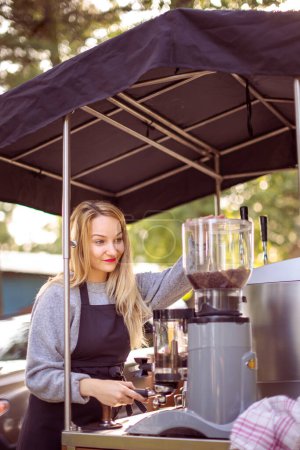 Foto de Abogada femenina haciendo café para clientes en un puesto de café móvil al aire libre en una ciudad - Imagen libre de derechos