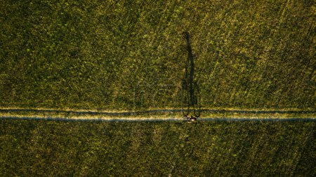 Téléchargez les photos : Image aérienne d'un cycliste sur un VTT au milieu de champs à l'extérieur - en image libre de droit