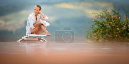 Foto de Joven hermosa bronceada mujer con gafas de sol relajante al lado de una piscina en un hermoso día de verano - Imagen libre de derechos
