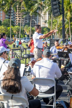 Téléchargez les photos : Le maire de Miami Francis X. Suarez dirige l'Orchestre symphonique de Miami au Peacock Park à Coconut Grove, FL, le 4 juillet 2022 - en image libre de droit