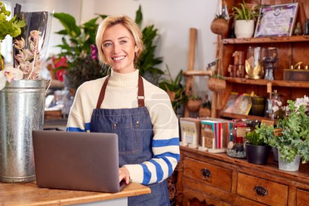 Portrait Of Female Owner Of Florists Shop Using Laptop