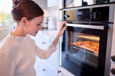 Frau In Küche Zu Hause Beobachten Hausgemachte Pizza Im Ofen Backen