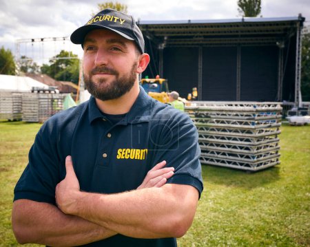 Hombre miembro del equipo de seguridad al aire libre como escenario para el festival de música o concierto se establece