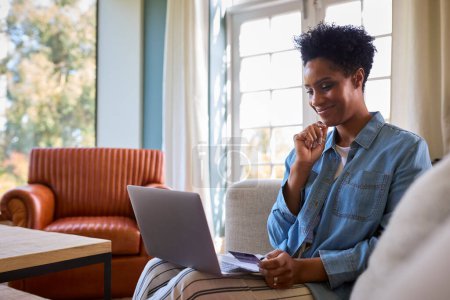 Excited Woman At Home With Laptop Using Credit Card To Make Online Purchase Or Book Tickets