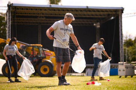 Voluntarios recogiendo basura después de un evento al aire libre como concierto o festival de música