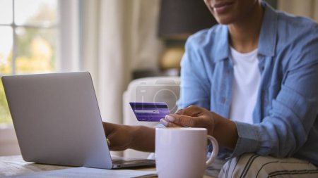 Close Up Of Woman At Home With Laptop Using Credit Card To Make Online Purchase Or Book Tickets