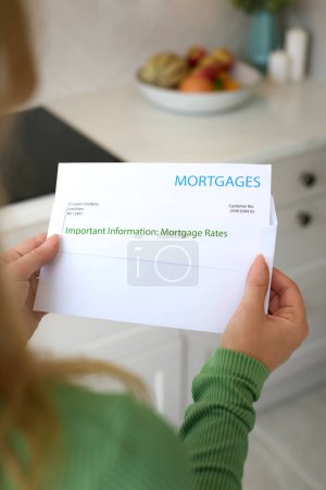 Close Up Of Woman Opening Letter About Increase in Mortgage Rate During Cost Of Living Crisis