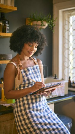 Frau arbeitet in nachhaltigem Kunststoff Free Grocery Store überprüft Aktien in den Regalen mit digitalem Tablet