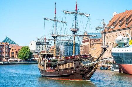 Foto de El barco de recreo en el río Motlawa. Carabela pirata en el río Motlawa y edificios históricos en el fondo en el casco antiguo, Europa, Gdansk, Polonia. - Imagen libre de derechos
