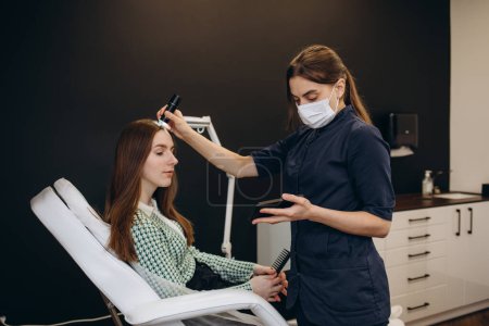 Photo for Consultation with a dermatologist. A trichologist examines the hair of a woman - Royalty Free Image