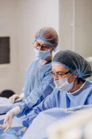 Téléchargez les photos : Un chirurgien phlébologue effectue une opération sur les jambes avec des varices à l'aide d'un. - en image libre de droit