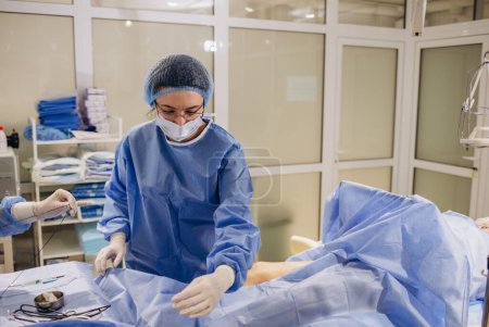 Téléchargez les photos : Un chirurgien phlébologue effectue une opération sur les jambes avec des varices à l'aide d'un. - en image libre de droit