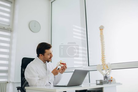 Photo for A vertebrologist consults a patient on the Internet. - Royalty Free Image