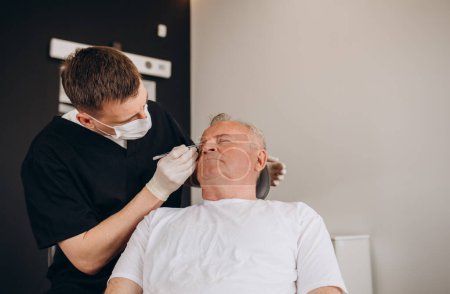Photo for Mature man being examined by a plastic surgeon. - Royalty Free Image