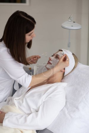Téléchargez les photos : Femme masquée sur le visage dans un salon de beauté spa - en image libre de droit