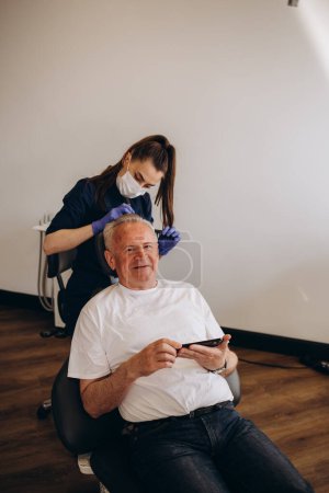 Photo for An old man is being examined by a trichologist. - Royalty Free Image