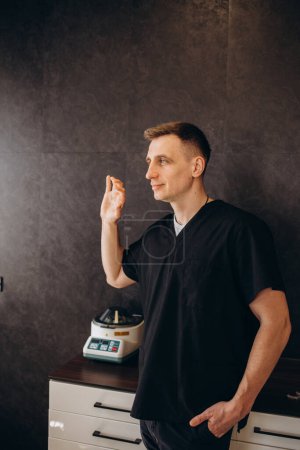 Téléchargez les photos : Portrait d'un dentiste tenant des aligneurs dans sa main. - en image libre de droit