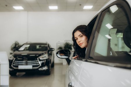 Photo for Photo of happy young mixed race woman showing key to her new car. Concept for car rental. - Royalty Free Image