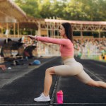 young woman warms up before jogging on stadium, People sport and fitness concept