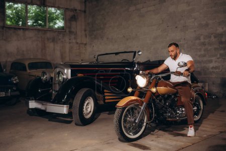 Foto de El hombre es un coleccionista de coches retro y motocicletas retro. - Imagen libre de derechos
