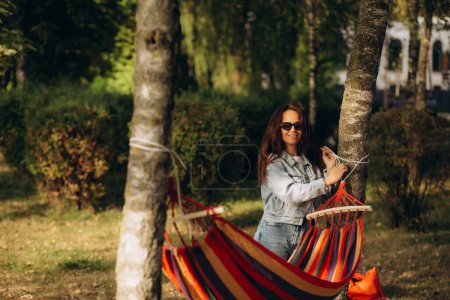 Photo for Woman ties up hammock in forest between trees. High quality photo - Royalty Free Image