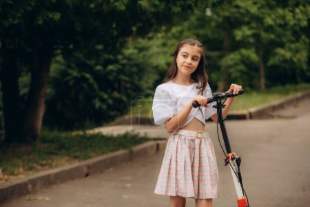 Photo for Little girl riding a kick scooter on a street near home. High quality photo - Royalty Free Image