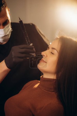 Photo for Experienced plastic surgeon consulting beautiful woman while using calipers. Copy space on right side. - Royalty Free Image