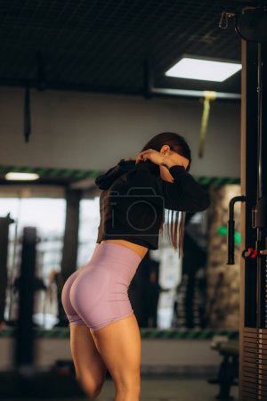 Photo for Woman trains buttocks and thighs in the gym. - Royalty Free Image