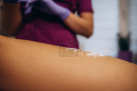 Foto de La mano cosmetóloga espolvorea talco en la axila de una mujer joven antes del procedimiento de depilación. Epilación y azucaramiento de la axila. Foto de alta calidad. Foto de alta calidad - Imagen libre de derechos