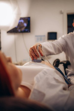 Cropped view of the male doctor holding special device while making ultrasound therapy for woman. Ultrasound of the veins of the upper xtremities concept. High quality photo