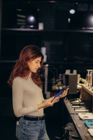eine Frau kauft eine elektrische Zahnbürste in einem Elektronikgeschäft