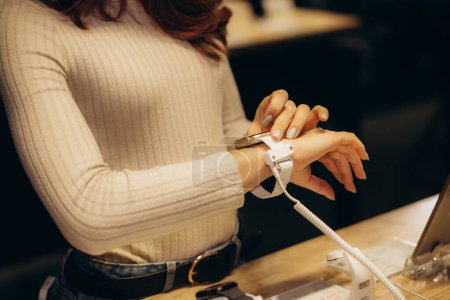 Eine Frau kauft in einem Elektronikgeschäft eine smarte Uhr