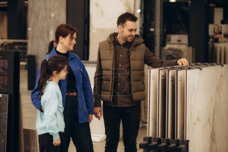 a young family chooses tiles for their home in a hardware store