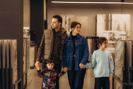 a happy family chooses tiles in the bathroom at a hardware store. High quality photo