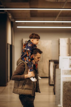 Téléchargez les photos : Un père avec un jeune fils dans une quincaillerie - en image libre de droit