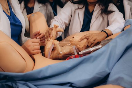 Medizinstudentin mit schwangerer Schaufensterpuppe auf der Krankenhausstation. Arztpraxis, Gesundheitskonzept. Hochwertiges Foto